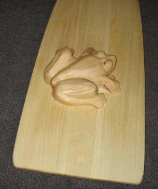Carved frog sitting on a paddle