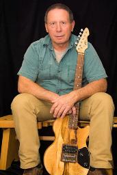 Don Bastian holding carved guitar